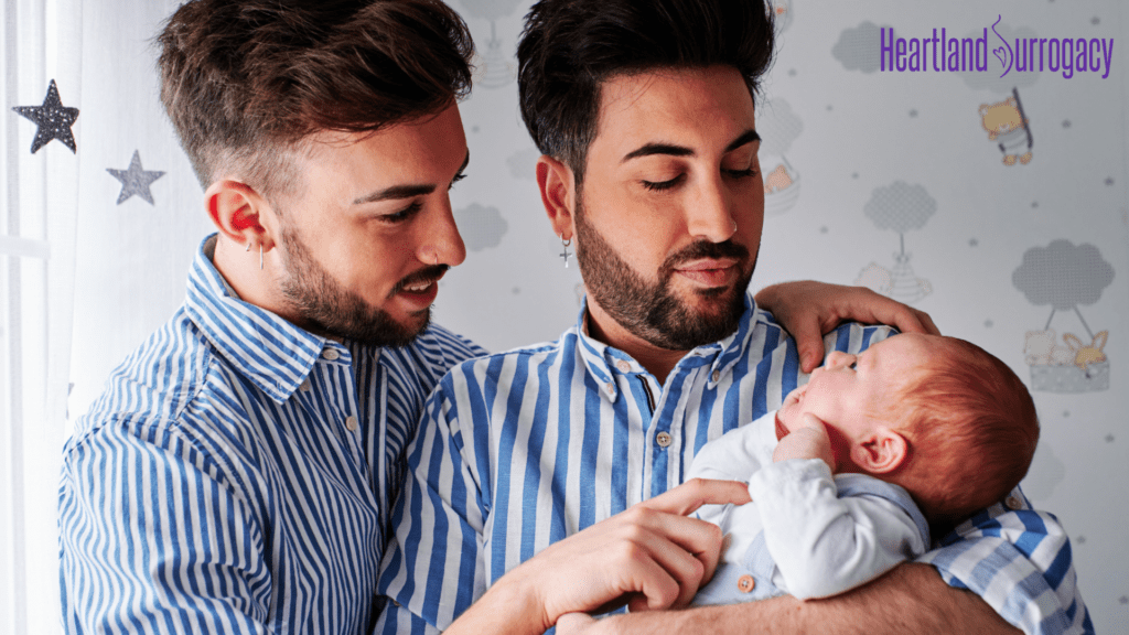 New dads looking lovingly at their baby after a surrogate delivery. 