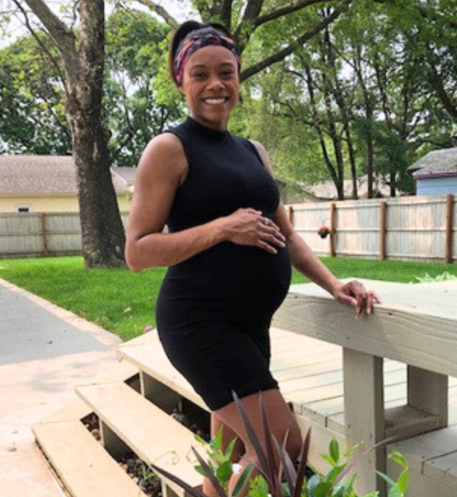 Black surrogate holding pregnant belly, surrogate for gay couple with twins