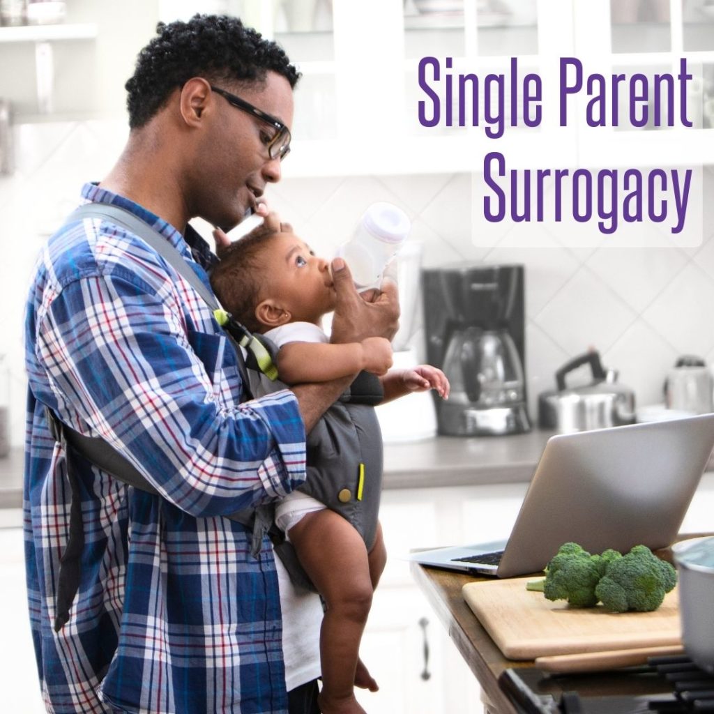 black single father through surrogacy holds baby in baby carrier