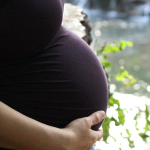 Minnesota surrogate mother holding surrogacy pregnancy bump