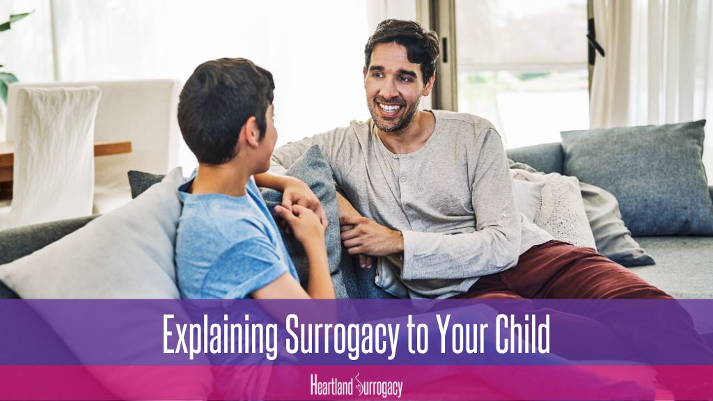 gay father through surrogacy talks to his child about being born through surrogacy. Text reads "Explaining Surrogacy to Your Child". Heartland Surrogacy logo.