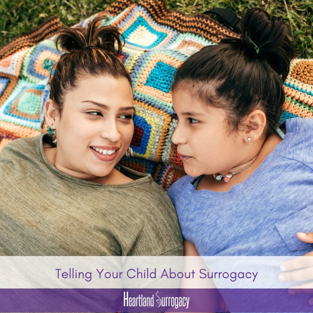 BIPOC mother through surrogacy explains surrogacy to child. Text "Telling Your Child About Surrogacy." Heartland Surrogacy logo