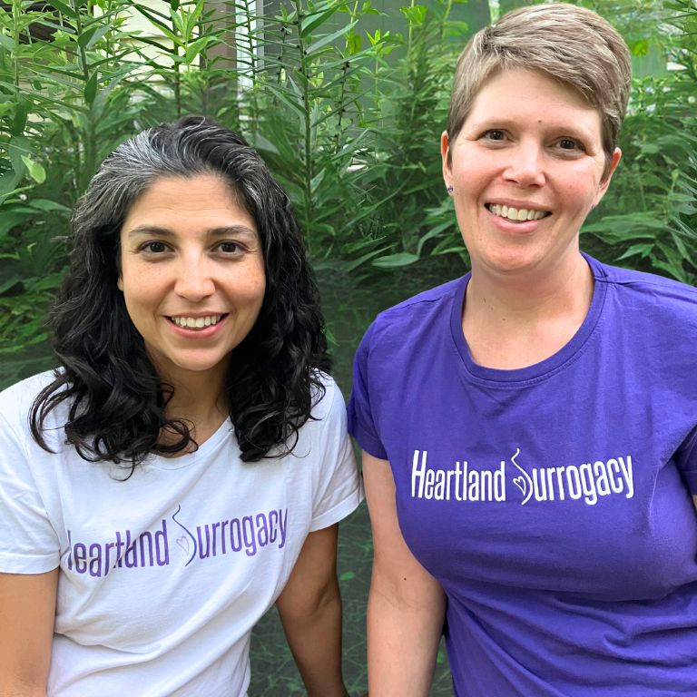 bipoc surrogacy agency owner and female surrogacy agency owner together wearing Heartland Surrogacy t-shirts
