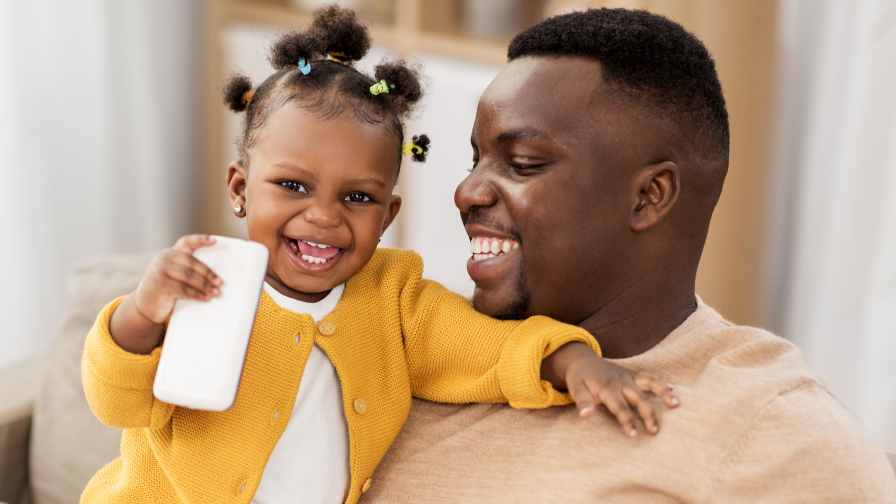 Black single father through surrogacy holding baby girl through surrogacy